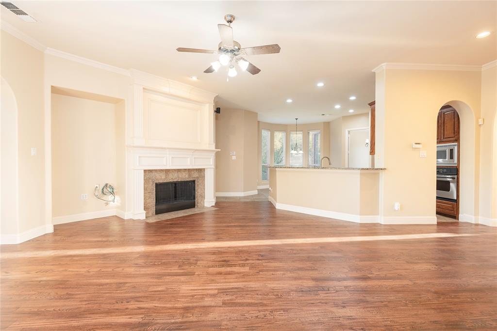 1404 Rio Grande Drive Allen, TX 75013 - Photo 40 of 40 a view of a livingroom with a fireplace a ceiling fan and kitchen view