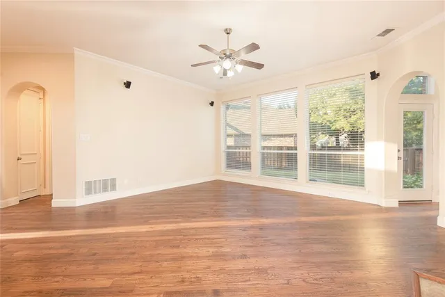 a view of a livingroom with a fireplace a ceiling fan and kitchen view