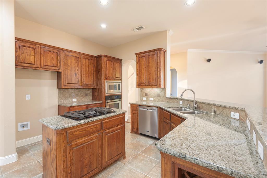 1404 Rio Grande Drive Allen, TX 75013 - Photo 14 of 40 a kitchen with stainless steel appliances granite countertop a stove a sink dishwasher and a refrigerator