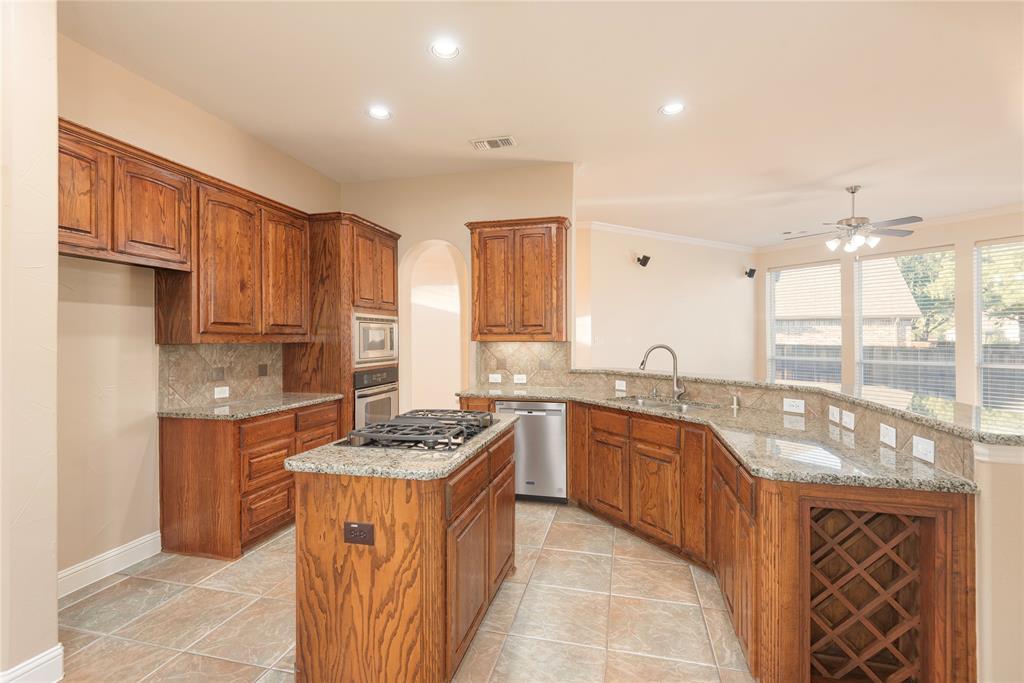 1404 Rio Grande Drive Allen, TX 75013 - Photo 15 of 40 a kitchen with stainless steel appliances granite countertop a sink stove and refrigerator