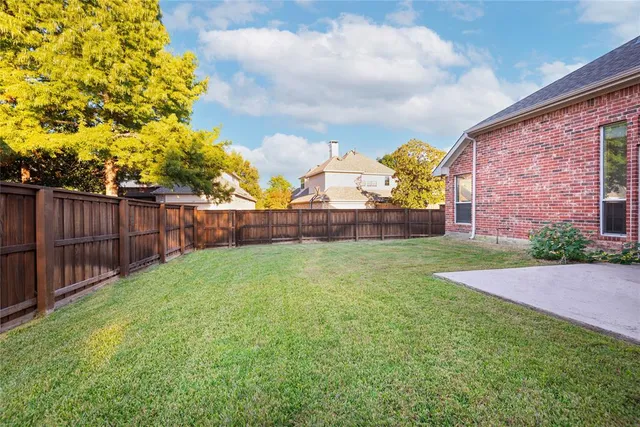 a view of a backyard with wooden fence