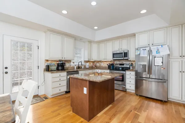 a kitchen with stainless steel appliances granite countertop a refrigerator stove a sink and a microwave