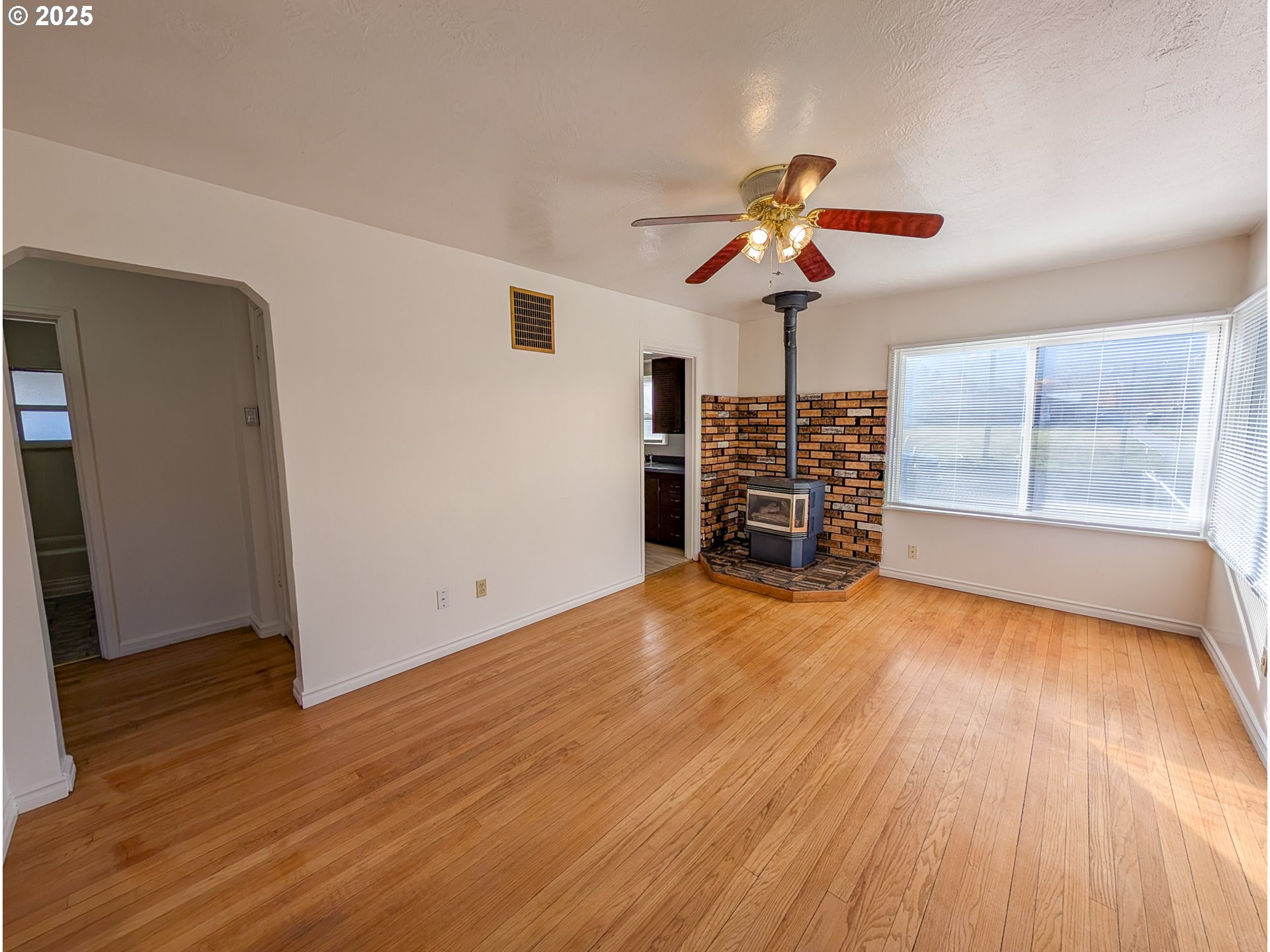901 2nd Street La Grande, OR 97850 - Photo 2 of 19 a view of a livingroom with wooden floor a ceiling fan and windows