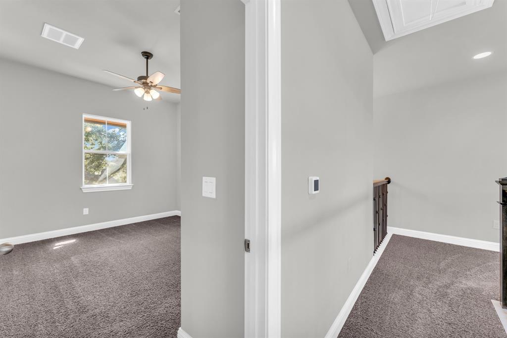 110 Magona Trail Georgetown, TX 78628 - Photo 27 of 38 A well-lit bedroom features a single window, ceiling fan, and plush carpet.