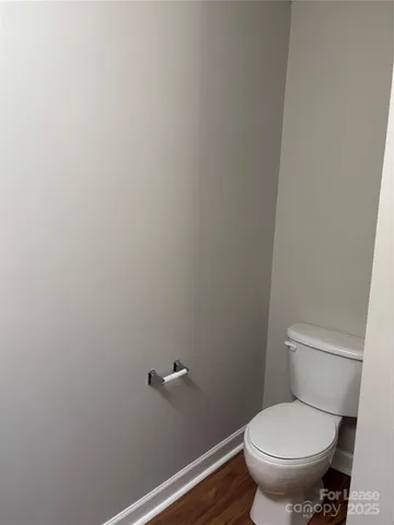 a white toilet sitting next to a white wall