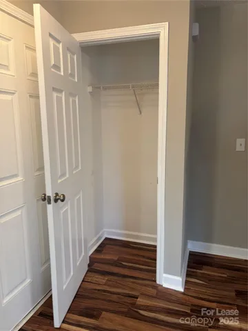a view of a hallway with wooden floor and entryway