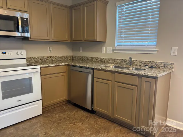 a kitchen with cabinets appliances and a sink