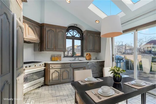 a kitchen with stainless steel appliances a sink cabinets and a window