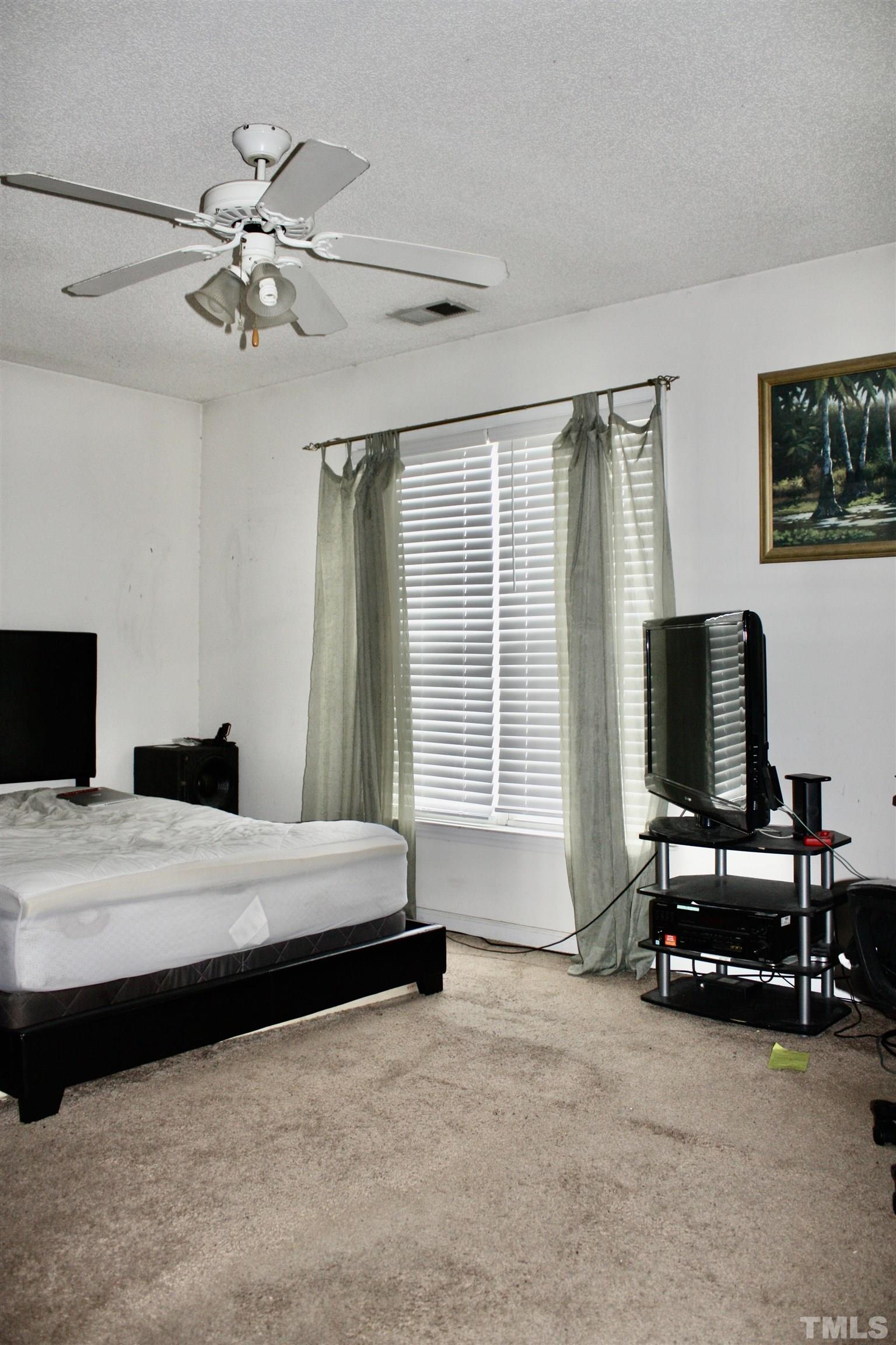 4702 Tanglewood Oaks Street Raleigh, NC 27610 - Photo 11 of 11 a bedroom with a bed and a flat screen tv