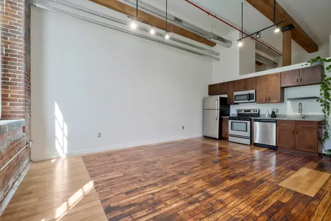 a view of kitchen with stainless steel appliances granite countertop a refrigerator and a stove top oven