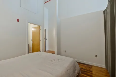 a bedroom with a bed and wooden floor