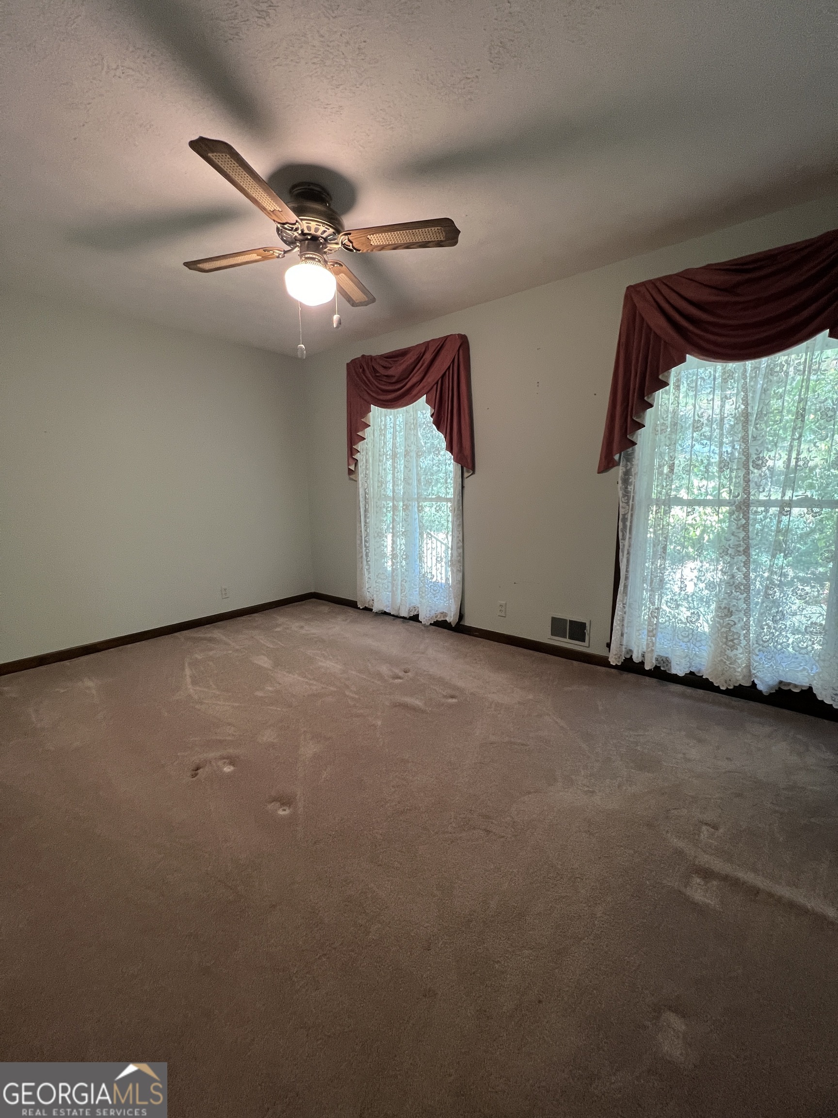1500 Pine Forest Road Mansfield, GA 30055 - Photo 42 of 47 an empty room with windows and ceiling fan