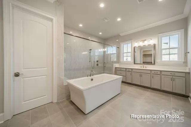 a bathroom with a double vanity sink mirror and bathtub