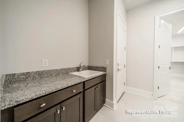 a bathroom with a granite countertop sink and white cabinets