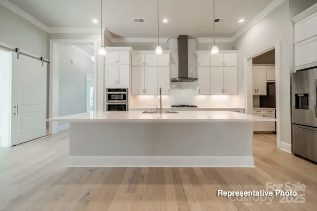a view of kitchen with refrigerator stove and wooden floor