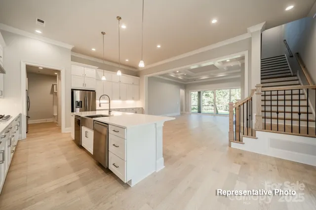 a large white kitchen with a large counter top and stainless steel appliances