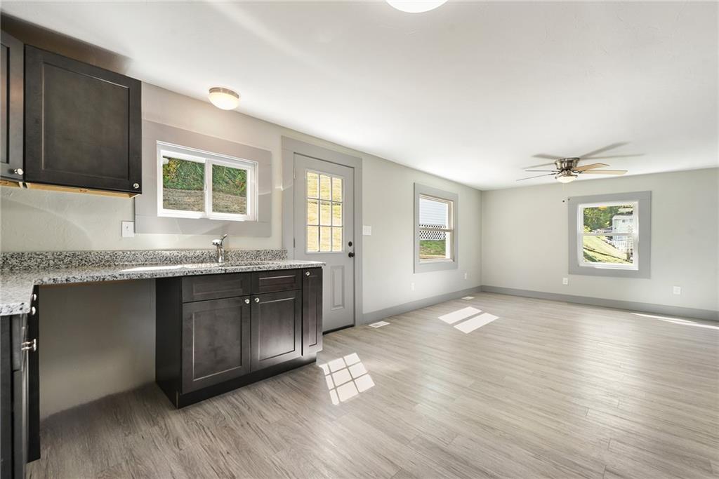 808 Mill Street Bridgeville, PA 15017 - Photo 11 of 27 a kitchen with granite countertop a stove a sink and a granite counter tops with wooden floors