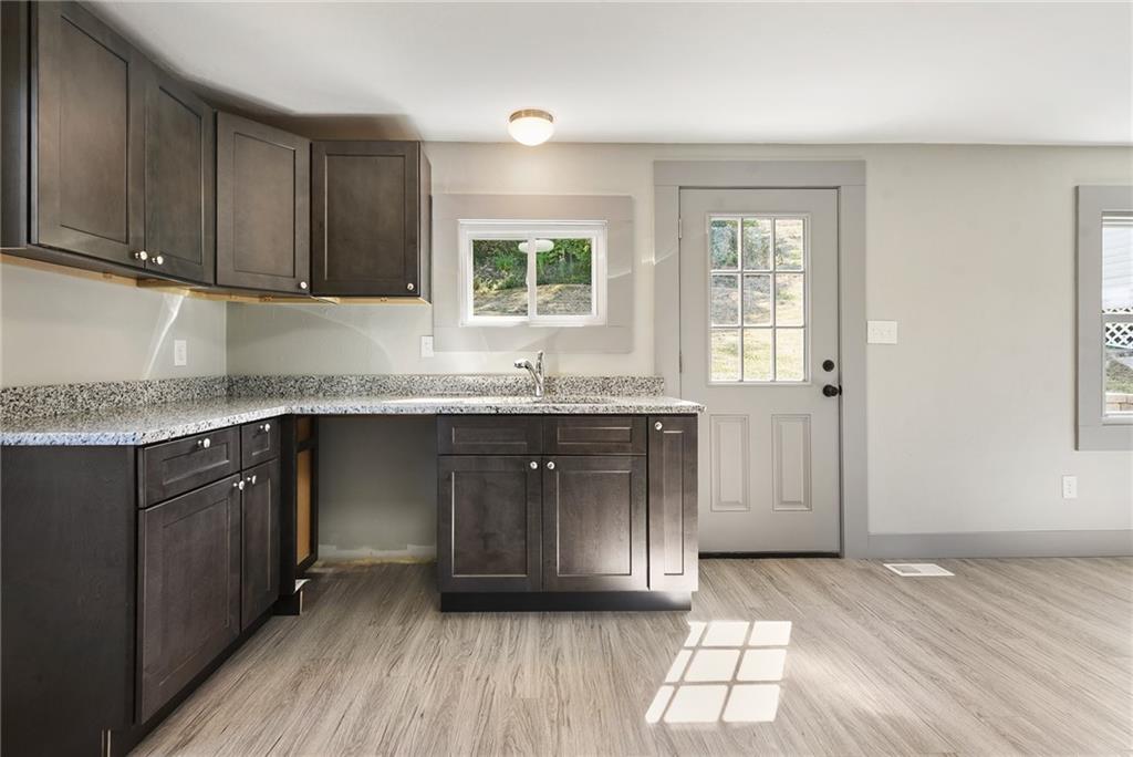 808 Mill Street Bridgeville, PA 15017 - Photo 9 of 27 a kitchen with granite countertop a sink a window and cabinets