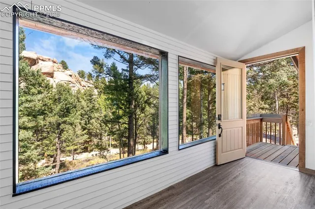 a living room with furniture a large window and wooden floor