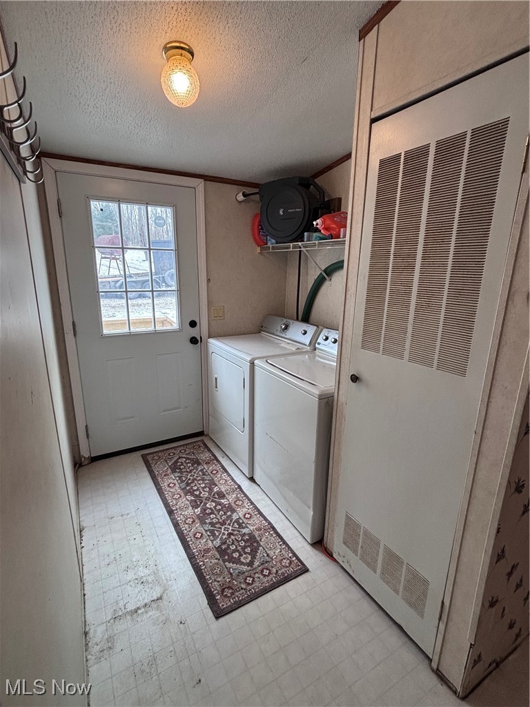 29311 Rabbit Ridge Road Howard, OH 43028 - Photo 15 of 39 Laundry room featuring light flooring, a heating unit, a textured ceiling, and washer and dryer