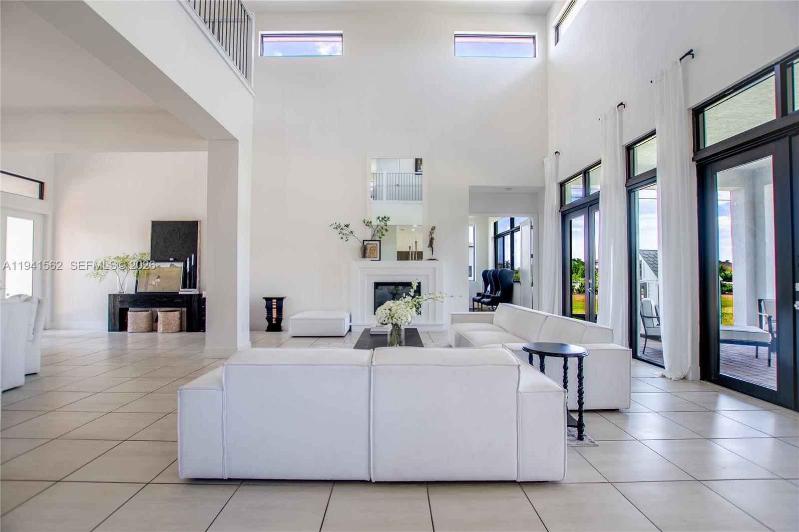 15821 Southwest 49th Street Southwest Ranches, FL 33331 - Photo 13 of 67 a living room with furniture a large window and a kitchen view