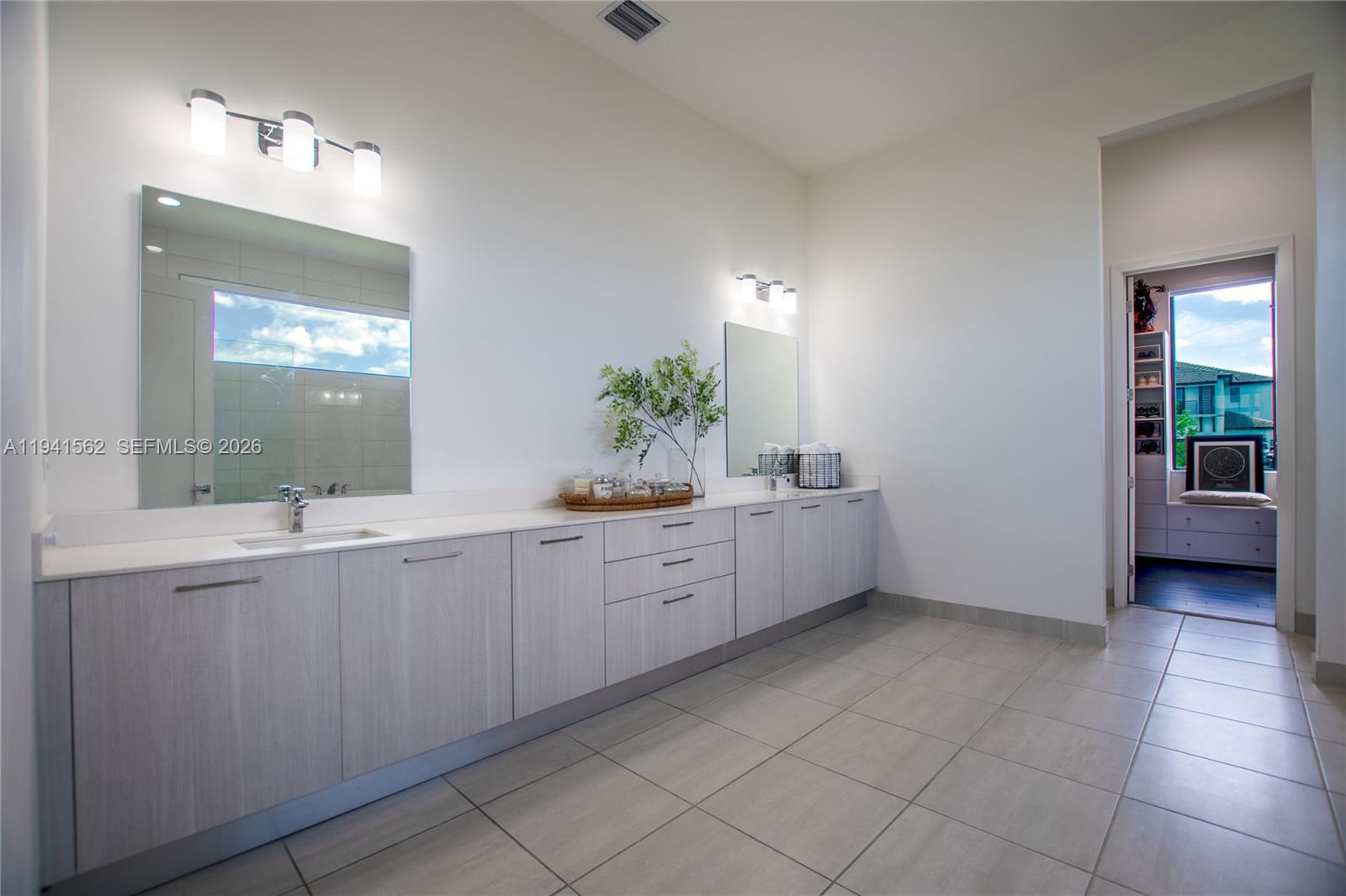 15821 Southwest 49th Street Southwest Ranches, FL 33331 - Photo 32 of 67 a large bathroom with a double vanity sink a mirror and a bathtub