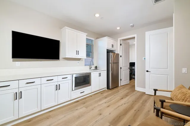 a kitchen with stainless steel appliances white cabinets and a wooden floor