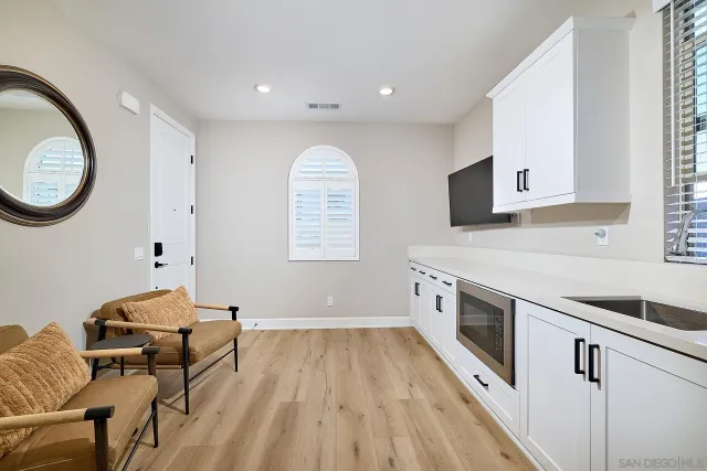 a kitchen with stainless steel appliances granite countertop a stove a sink and a microwave oven with white cabinets