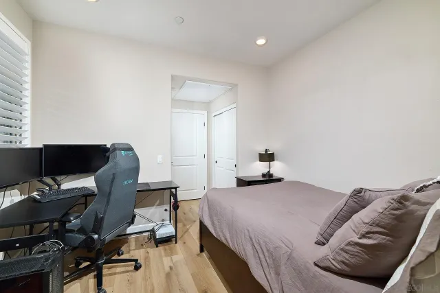 a bedroom with a bed and a computer on a desk