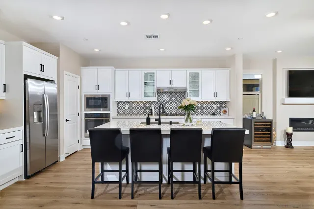a kitchen with stainless steel appliances kitchen island granite countertop a table and chairs in it