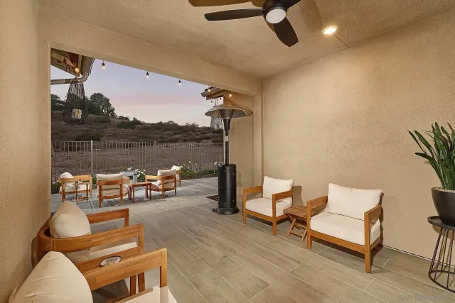 a living room with patio furniture and a floor to ceiling window