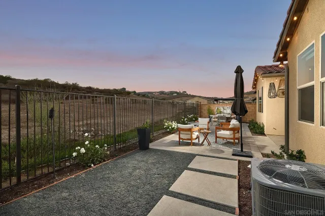 a view of a balcony with chairs and a potted plant