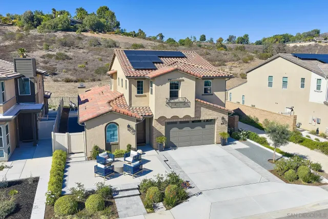 a view of a white house with a chairs in a patio