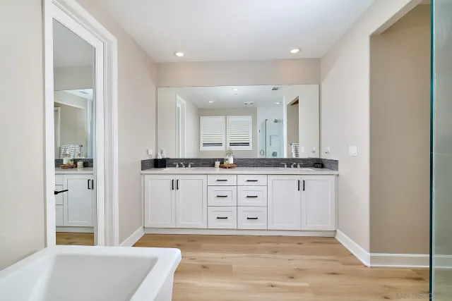 a spacious bathroom with a tub sink and mirror