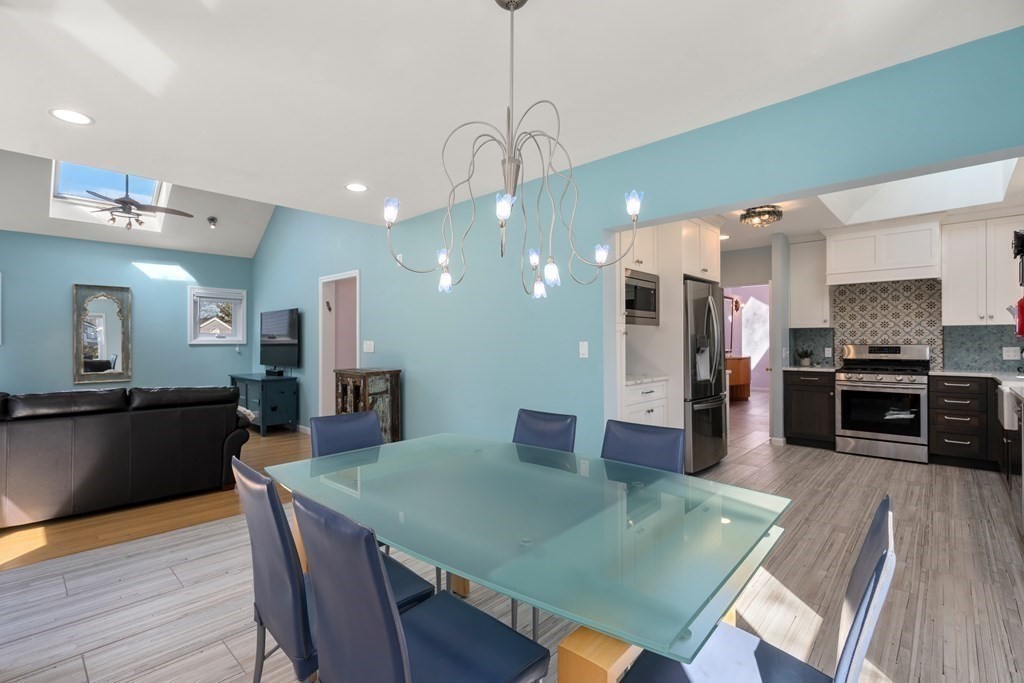 5 Mulberry Lane Canton, MA 02021 - Photo 7 of 36 a open kitchen with stainless steel appliances granite countertop a stove a refrigerator a kitchen island a table and chairs