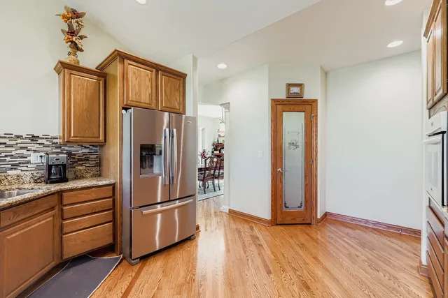 a kitchen with stainless steel appliances a refrigerator and wooden floor