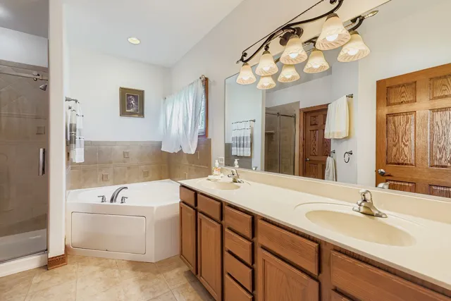 a bathroom with a sink a large mirror and a bathtub
