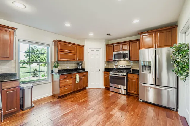 a kitchen with stainless steel appliances granite countertop a refrigerator stove top oven and sink