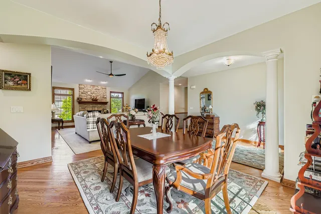 a view of a dining room and livingroom with furniture wooden floor a chandelier