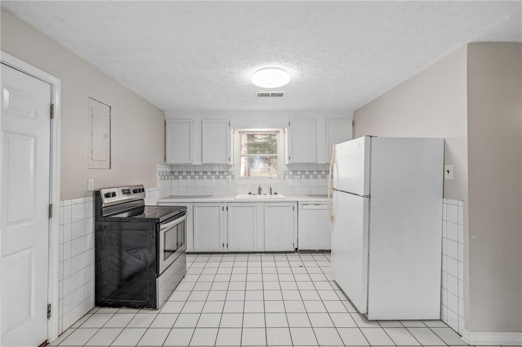 75 Lake Street Jefferson, GA 30549 - Photo 8 of 35 a kitchen with a sink a stove and refrigerator