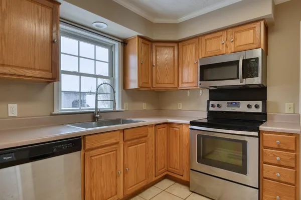 a kitchen with granite countertop a stove top oven microwave and cabinets