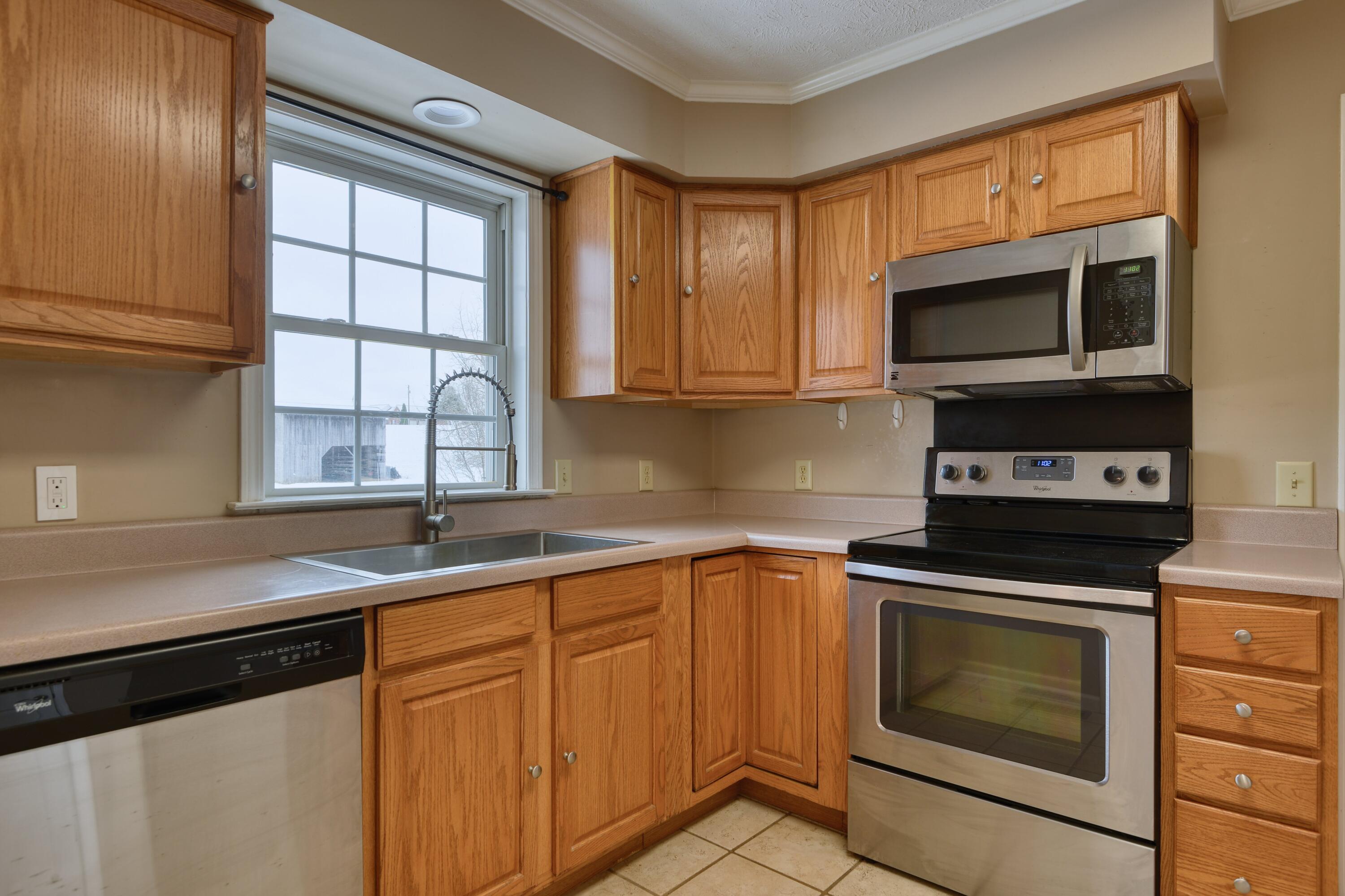 4530 Piney Woods Road Riner, VA 24149 - Photo 11 of 60 a kitchen with granite countertop cabinets stainless steel appliances a sink and a window