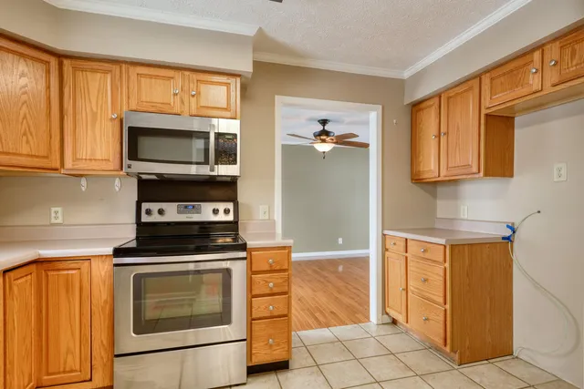 a kitchen with stainless steel appliances granite countertop a stove a sink and a microwave