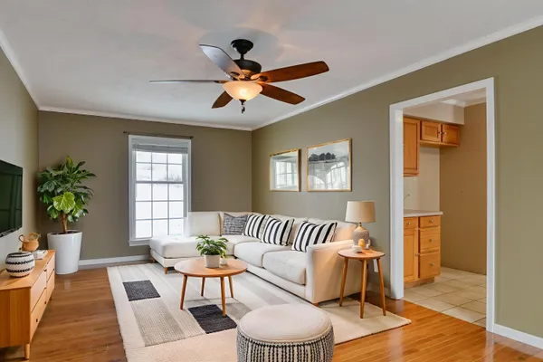 a spacious bedroom with a large bed a chandelier and windows