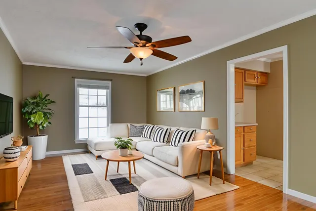 a spacious bedroom with a large bed a chandelier and windows