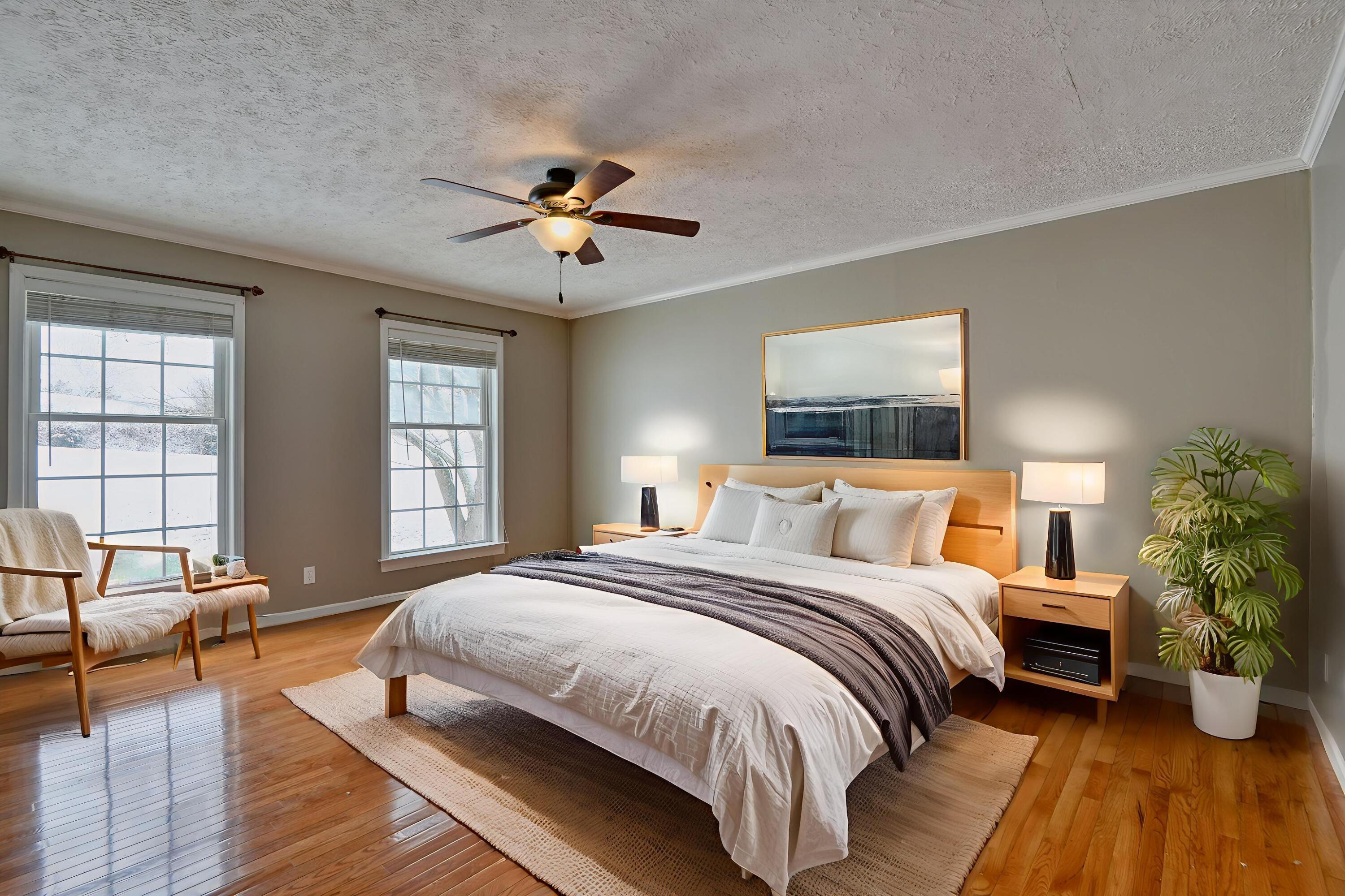 4530 Piney Woods Road Riner, VA 24149 - Photo 21 of 60 a spacious bedroom with a large bed a chandelier and windows