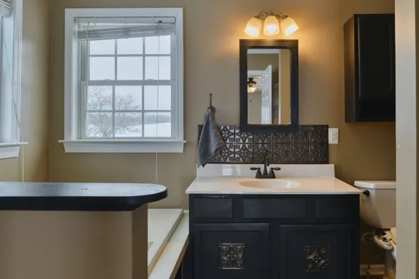 a bathroom with a sink a toilet a mirror and shower