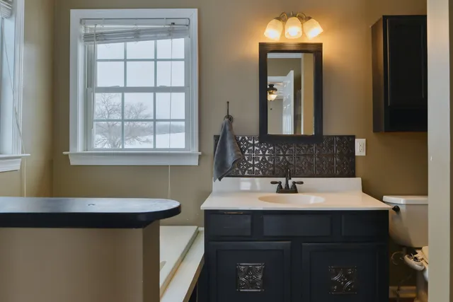 a bathroom with a sink a toilet a mirror and shower