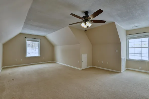 a view of a refrigerator in kitchen and an empty room