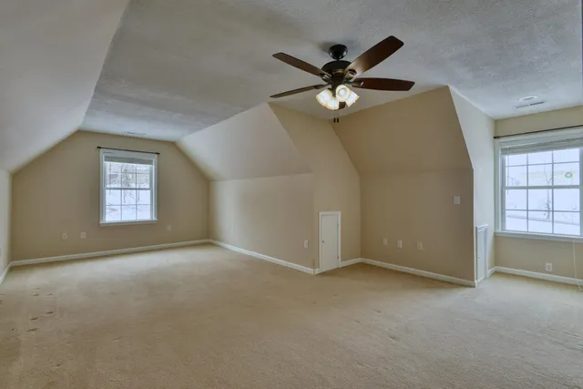 a view of a refrigerator in kitchen and an empty room